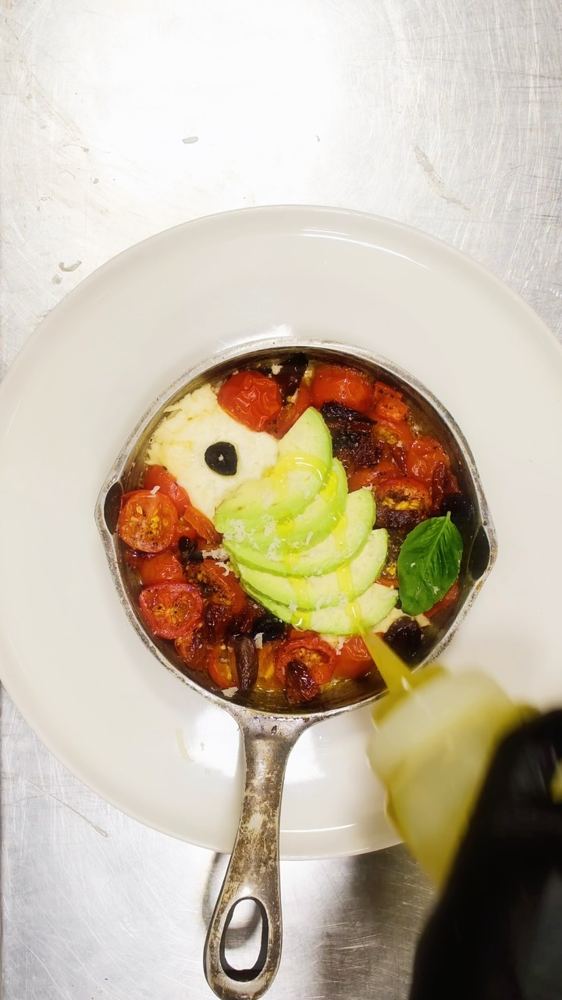 Baked feta with poached eggs in a skillet