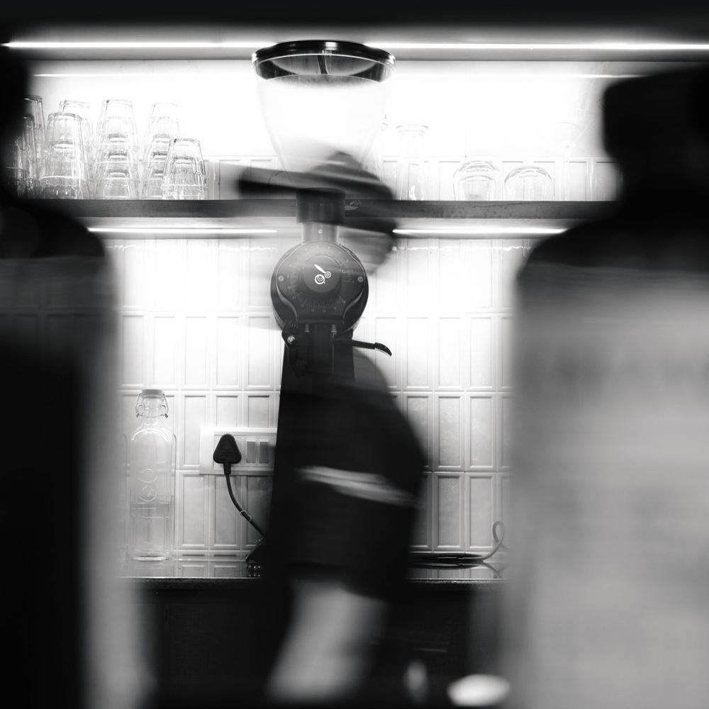 Barista at work behind the bar, black and white