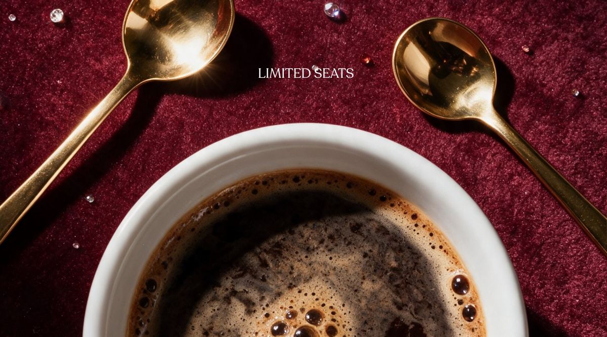 Gold cupping spoons beside a fresh cup of black coffee